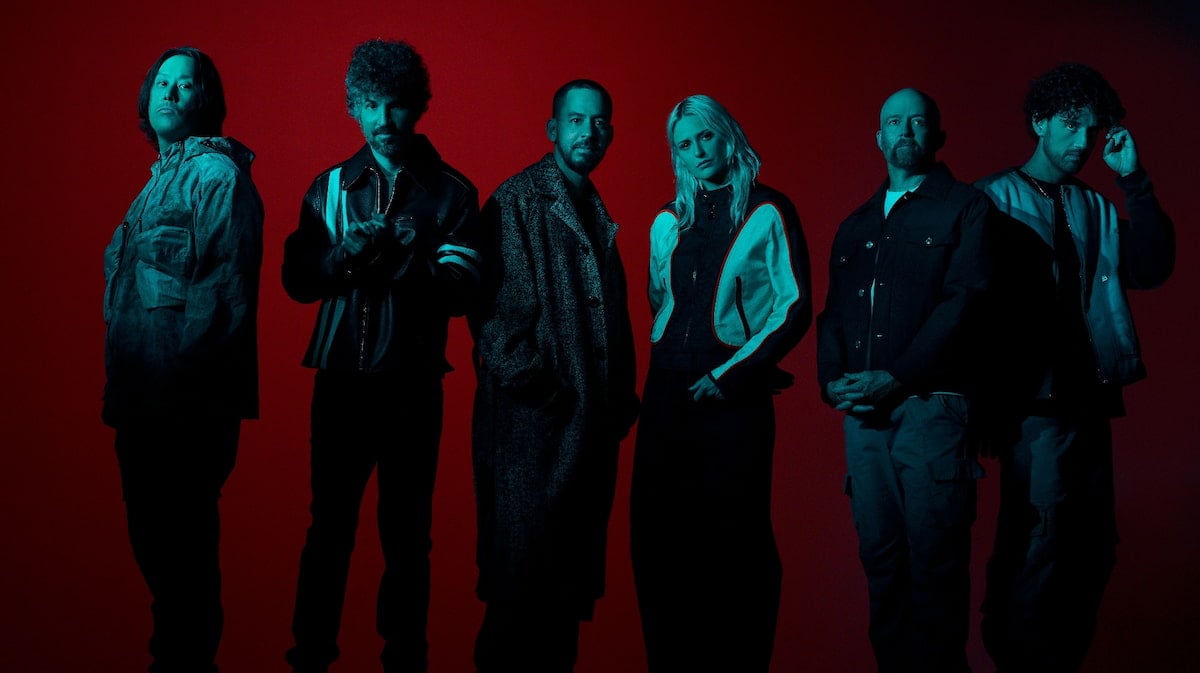 Linkin Park standing against a red background