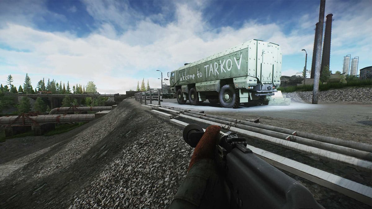 A player with a gun looks out upon the Customs map with a graffitied truck in front of them in Escape from Tarkov.